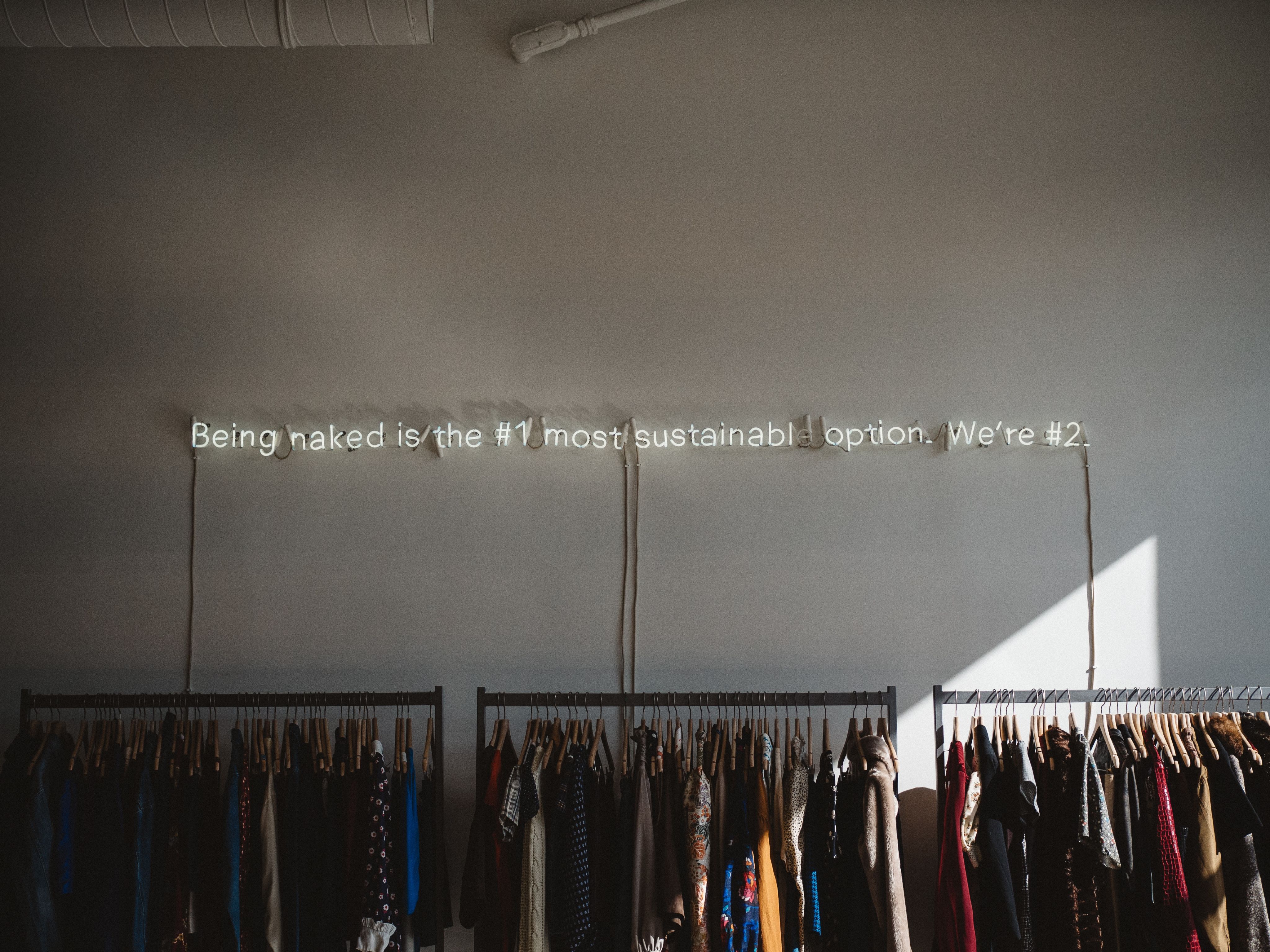 assorted clothes lot on gray clothes racks